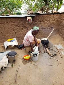 Woman in the village of Okortobu preparing an evening meal for her family.